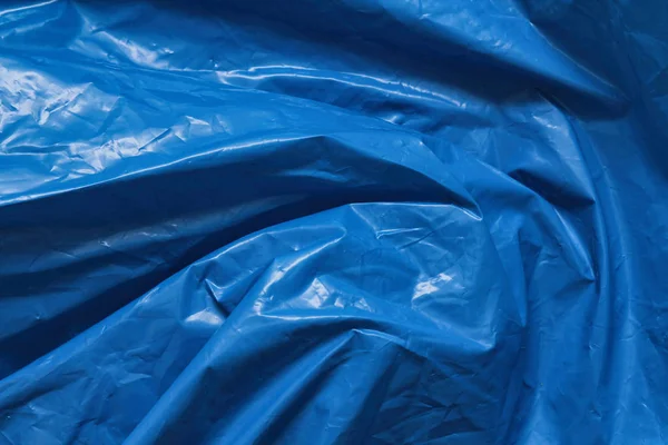 Blue plastic bag texture background. Waste recycling concept. Crumpled polyethylene and cellophane. Reuse materials.