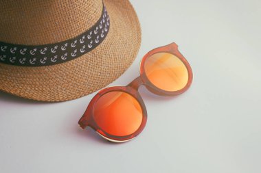 Beyaz arka planda hasır şapka ve kırmızı güneş gözlüğü. Tatil zamanı. Seyahat konsepti. Metin alanınız.