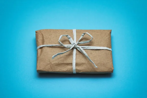 Paket Kahverengi Işi Kağıdına Sarılıp Mavi Kurdeleye Bağlanmış Paket Var — Stok fotoğraf