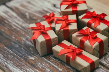 Bazı hediye kutuları kahverengi zanaat kağıt sarılmış ve kravat kırmızı saden kurdele. Dekoratif ahşap arka plan. Metin alanınız. Hediyeler seti.