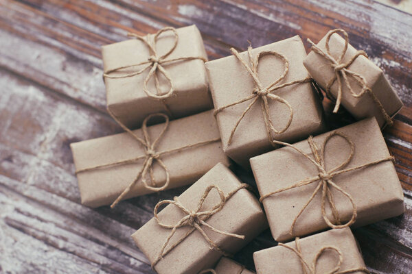 Комплект посылки завернутый в бумагу и галстук конопли шнур. Служба доставки. Интернет-доставка. Декоративный деревянный фон. Концепция рождественских подарков Много подарков
.