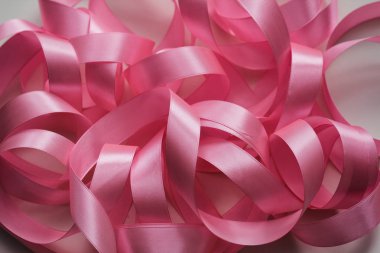 Beyaz arka planda pembe saten kurdele. Paketleme işlemi. İç dekorasyon. Düğün günü. Hediyeler ve hediyeler paketleniyor. 