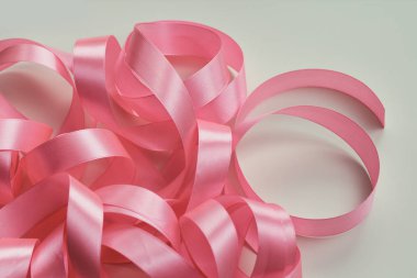 Beyaz arka planda pembe saten kurdele. Paketleme işlemi. İç dekorasyon. Düğün günü. Hediyeler ve hediyeler paketleniyor. 