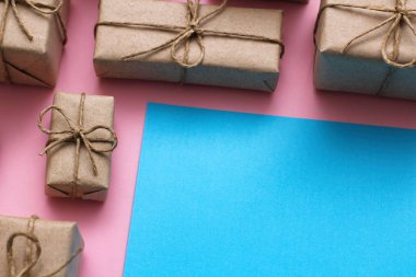 Cinsiyet belirleme günü konsepti. El işi kağıt ve kravat ipliğine sarılı bir hediye kutusu. Pembe ve mavi arka planlar. Kız ya da erkek. Doğum günü partisi.