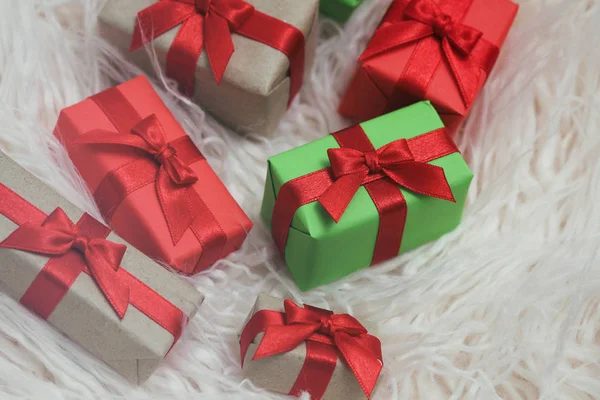 Set of gift boxes wrapped in craft paper and tie red satin ribbon. Christmas presents. Holiday mood. New year decor. Gift exchange.