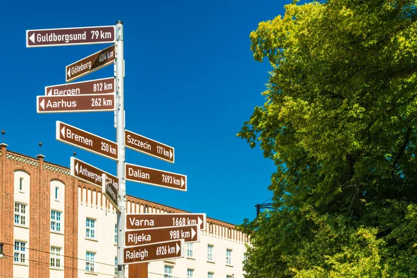 Sokak tabelası yön işaretçiler ve mesafeler dünyanın farklı şehirler için. Rostock, Almanya