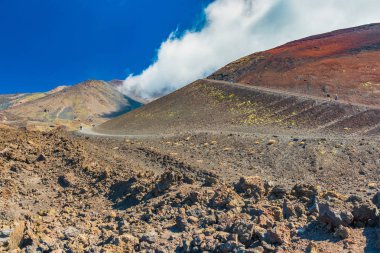 Etna Dağı'nda lav taşı tarlaları ve tepeleri, Sicilya, İtalya. Volkanik krater yakınındaki tepeye kadar yürüyen yaşlı çiftler