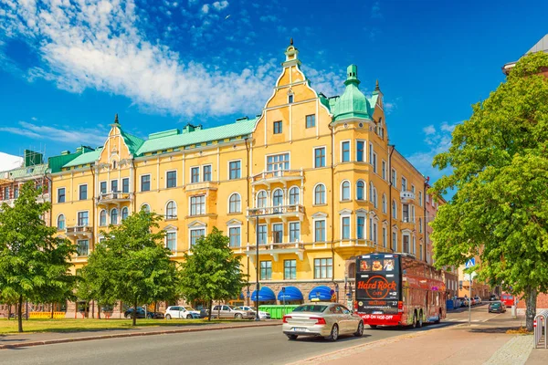 Helsinky - červen 2019, Finsko: Ulice v Helsinkách s automobilovou dopravou a starý žlutý dům v tradičním architektonickém stylu — Stock fotografie