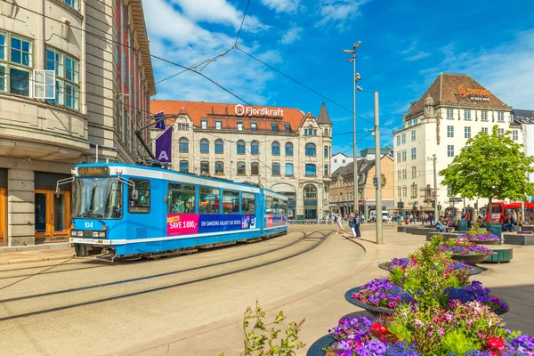 Oslo - Junho de 2019, Noruega: Vista de uma rua com um bonde azul, edifícios históricos antigos e belos canteiros de flores no centro de Oslo — Fotografia de Stock