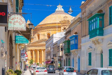 Mosta - Mayıs 2025, Malta: Geleneksel Malta mimarisine sahip Triq Il-Kungress Caddesi üzerinden Rotunda Mosta Kubbesi manzarası.