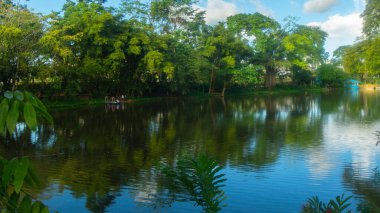 Nueva Loja, Sucumbios / Ekvador - 21 Aralık 2019: Bulutlu bir öğleden sonra Julio Marin gölünde bir çift kürek çekiyor. Şehir aynı zamanda Lago Agrio olarak da bilinir.