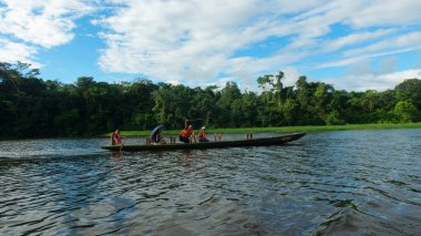 Nueva Loja, Sucumbios / Ekvador - 22 Aralık 2019: Turistler, Nueva Loja kenti yakınlarında güneşli bir günde Pearl Park Gölünde bir botla seyahat ediyorlar