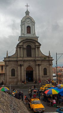 Riobamba, Chimborazo / Ecuador - February 10 2019: People shopping at the market next to the church of San Antonio de Padua, built in the 19th century with a neoclassical style clipart