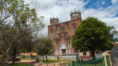 Santiago de Calpi, Chimborazo / Ekvador - 10 Şubat 2019: Bulutlu bir günde Calpi Bazilikası 'nın yanındaki Central Park' ta yürüyen insanlar