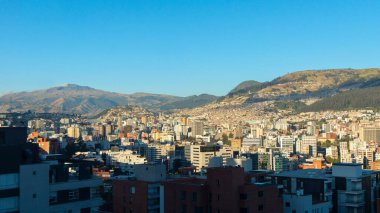 Quito şehrinin merkez bölgesinin panoramik manzarası. Güneşli bir sabahta arka planda Atacazo dağı var.