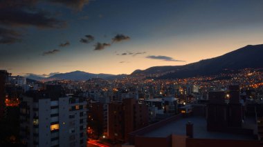 Quito şehrinin merkezinin panoramik manzarası gün batımında açık bir gökyüzüyle - Ekvador