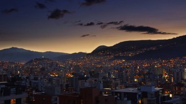 Quito şehrinin merkezinin panoramik manzarası gün batımında açık bir gökyüzüyle - Ekvador
