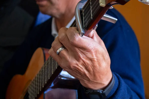 Podejście Dłoni Starszego Mężczyzny Trzymającego Gitarę Obrączką Palcu Brązowym Tle — Zdjęcie stockowe