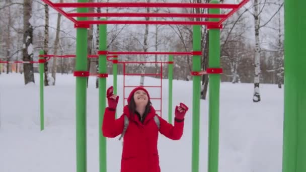 Woman walking alone in winter landscape in moody weather hiking girl wearing red jacket with hood walk in snowy landscape — Stock Video