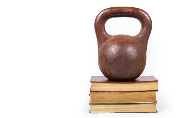 Power of knowledge. Weight on stack of books. Old iron weight. Copy space