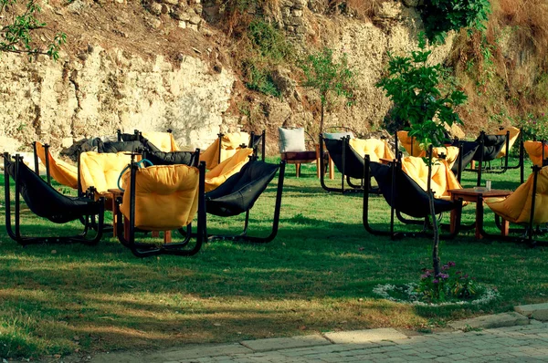 Yellow chair bag on the grass in a cafe. The interior of the summer cafe. Summer furniture in a restaurant.