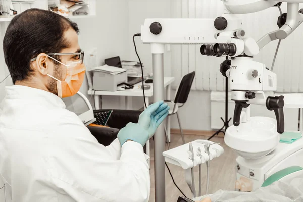 Young male dentist doctor at his workplace. Professional uniform and equipment of a dentist. Healthcare Equipping a doctors workplace. Dentistry