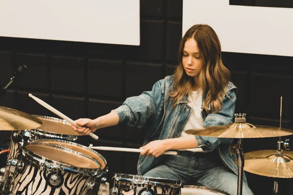 Creativity and music. Young beautiful girl plays the drums. Recording Studio. Musical equipment.