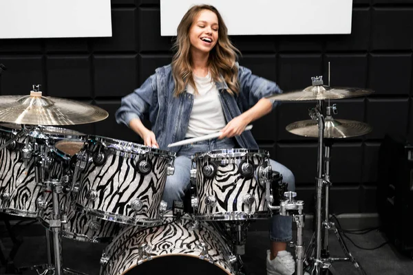 Creativity and music. Young beautiful girl plays the drums. Recording Studio. Musical equipment.