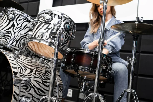 Creativity and music. Young beautiful girl plays the drums. Recording Studio. Musical equipment.