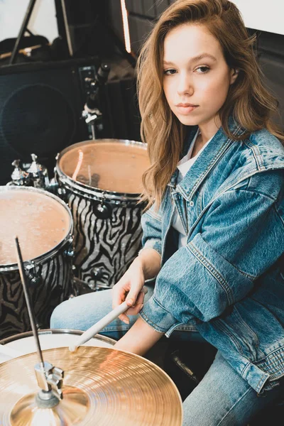 Creativity and music. Young beautiful girl plays the drums. Recording Studio. Musical equipment.