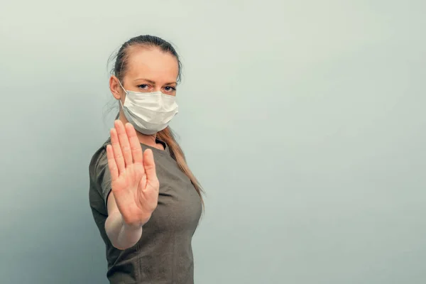 A girl is putting on a protective mask. Respiratory protection from coronavirus. Keep the distance. Personal protective equipment for a pandemic of a viral infection. Covid-19.