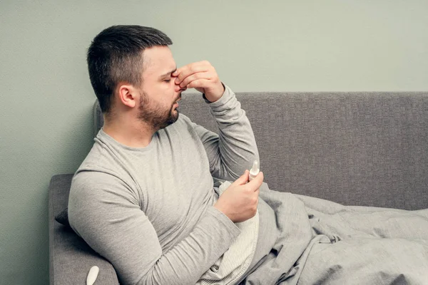 Disease. Cheer at home. A young man is sick, is treated at home. Blows her nose into a napkin, runny nose. Infection, epidemic, bacillus carrier.