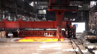 Metalürji fabrikasında kene ile çalışan vinç ve ısıtma kuyuları. Metalürjik külçeler. Giriş çukur vinci