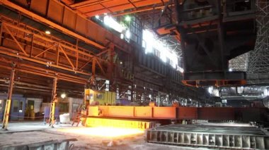 Metalürji fabrikasında kene ile çalışan vinç ve ısıtma kuyuları. Metalürjik külçeler. Giriş çukur vinci