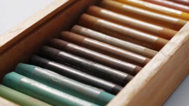 Pastel boya kalemlerinin dönüşünün yakın çekim. Pastel boya kalemleri özel bir kutu boya. Pastel boya ile boyama için aksesuarlar. Sanat kavram okulu ve çizim eğitimi. Yumuşak odaklama.
