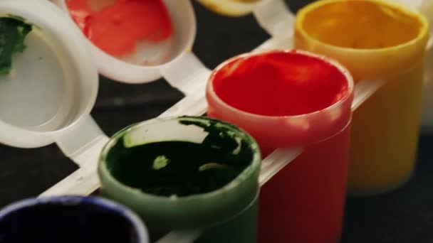 塑料罐上的多色水粉 旋转多色背景 黑背景上有很多五颜六色的油漆水罐 — 图库视频影像
