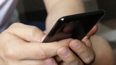 Modern Akıllı Telefon Tutan Mans Hands yakın. Siyah metalik mobil cihazda mesaj atan bir adamın elleri. 5g ve 4g ağlar için cep telefonu kullanımı ve bağlantı. Yumuşak odaklama