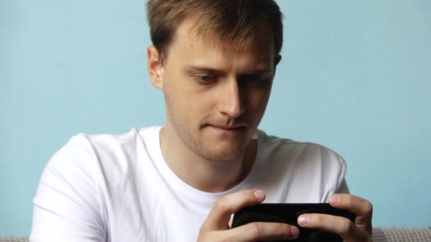 Serious Man Using Smartphone Playing Games Typing Message Sitting Sofa — Stock Video