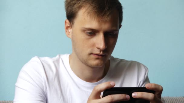 Serious Man Using Smartphone Playing Games Typing Message Sitting Sofa — Stock Video