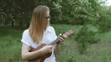 Akşam parkta Hawaiili ukulele oynayan genç bir kız böcekler tarafından ısırılır. Bir kadın bir ukulele yardımıyla böceklerden korunur.