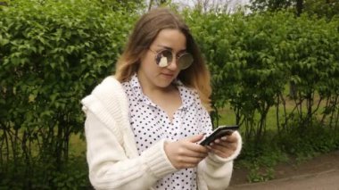 Güzel kadın açık havada cep telefonuyla mesaj atıyor. Pretty kız el cep telefonu tutun, akıllı telefon kişi tipi mesaj, yaşam tarzı tatil kavramı