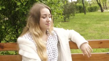 Parkta telefonda konuşan gülümseyen güzel bir kadının portresi. İlkbahar, yaz. Dinlenme kavramı. 