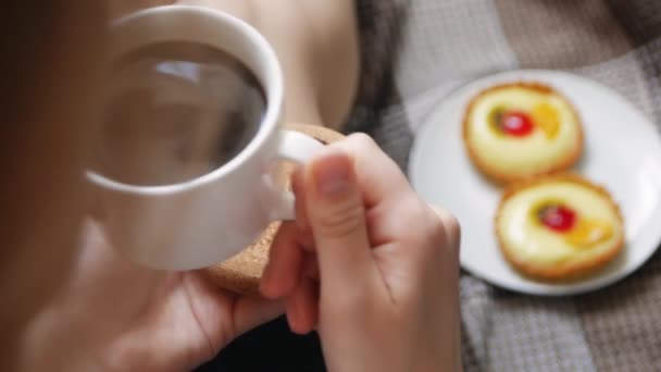 女孩醒来时在床上喝咖啡和蛋糕 美丽的年轻女子在她家喝咖啡在她的床上 在舒适的蓝色长袍 — 图库视频影像