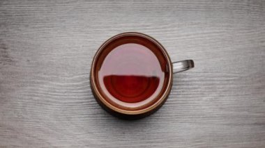 Beyaz bir arka plan üzerinde bir çay fincanı siyah çay içme - Hareket durdurun. Çay Time Lapse fincan. 
