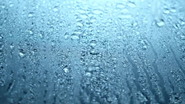 水滴落在玻璃上的特写镜头 雨从窗户上流下来 雨滴滴下来 灰色的天空 — 图库视频影像