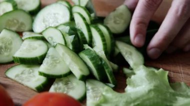 Mutfakta çelik büyük bir bıçak ile bir kesme tahtası üzerinde taze yeşil salatalık dilimleme. Close.
