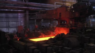 Çelik fabrikası, çelik levha üretimi, sıcak levhaların üretim hattında taşınması, ağır sanayi, metal haddeleme tesisi. Konveyör hattı metal haddehane.