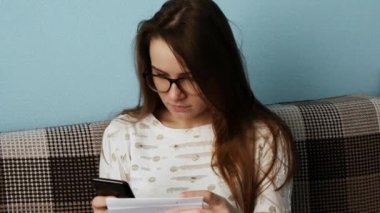 Elinde cep telefonu tutan kız. Akıllı telefondaki metni kağıt la yeniden yazma.