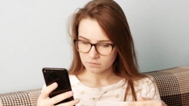 Memnun gülümseyen kadın faturaları ödedikten sonra bir kanepede oturan veya iyi haber okuduktan sonra. Ödüllendirme veya kolaylaştırma kavramı