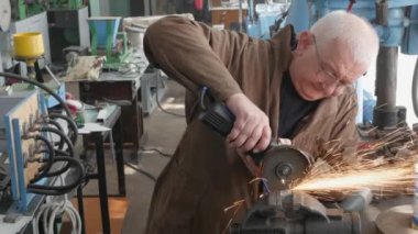 Endüstriyel atölyede çalışırken açı öğütücü kullanarak metal kesme mühendisi. Bir açı öğütücü ile metal kesim sırasında kıvılcım. 